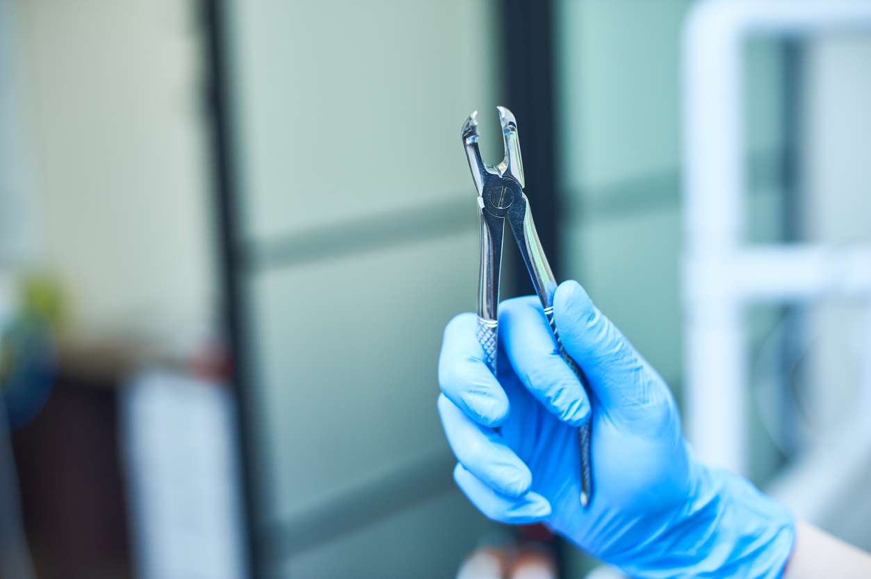 Dental pliers held by dentist with blue glove 2026 03 24 04 14 18 utc