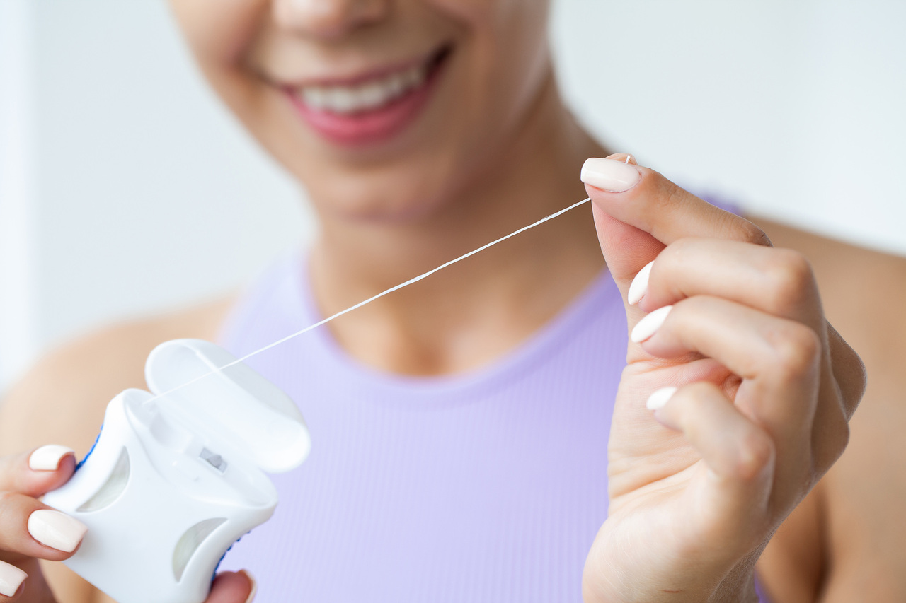 Woman smiling pulling out dental floss