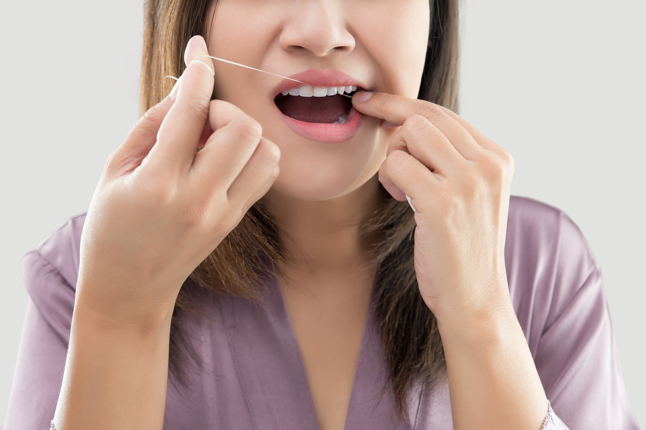 Woman flossing teeth
