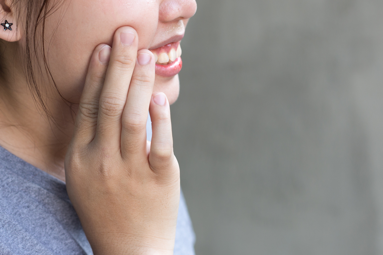 woman holding her cheek tooth ache healing