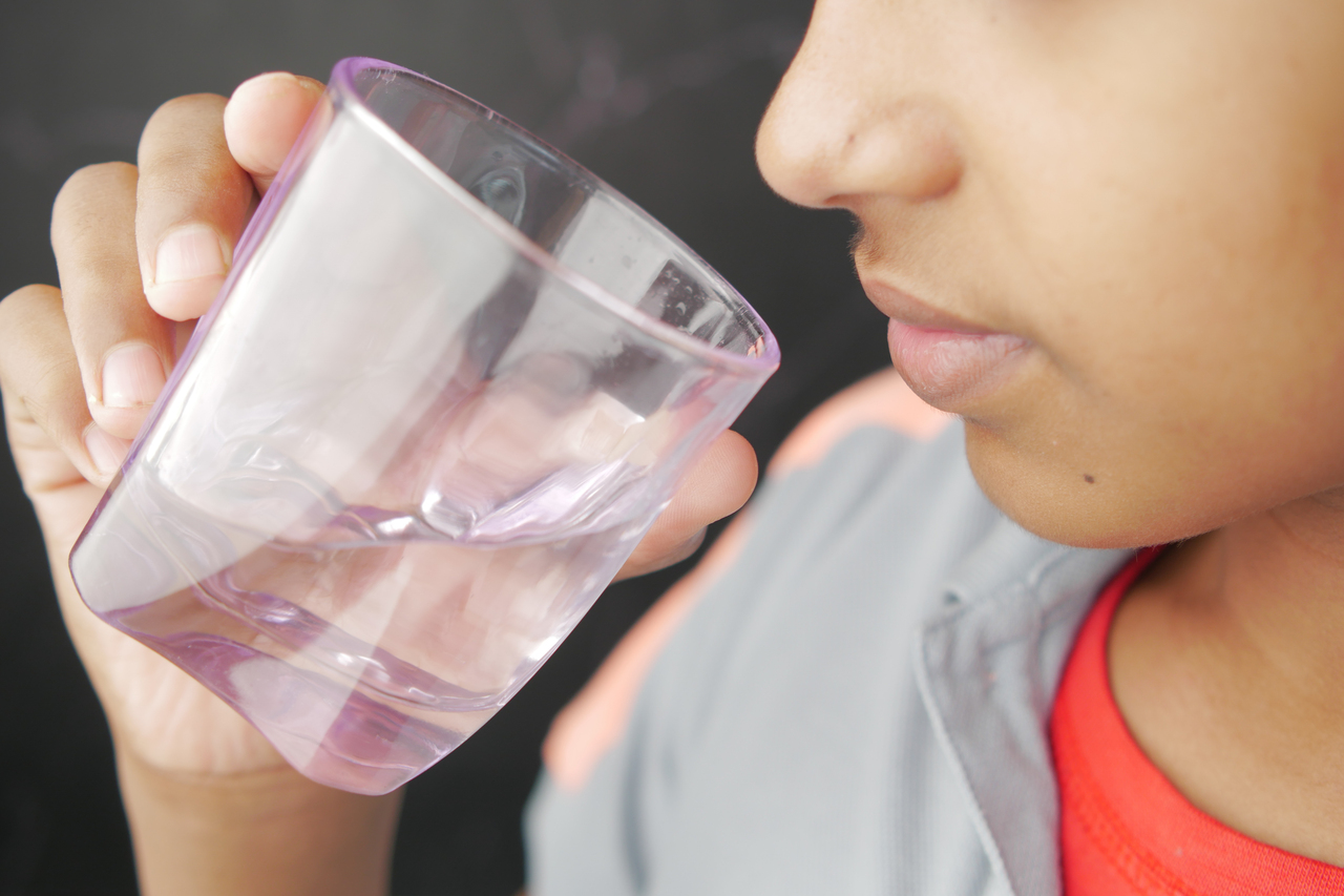 Boy gargling with cup of water